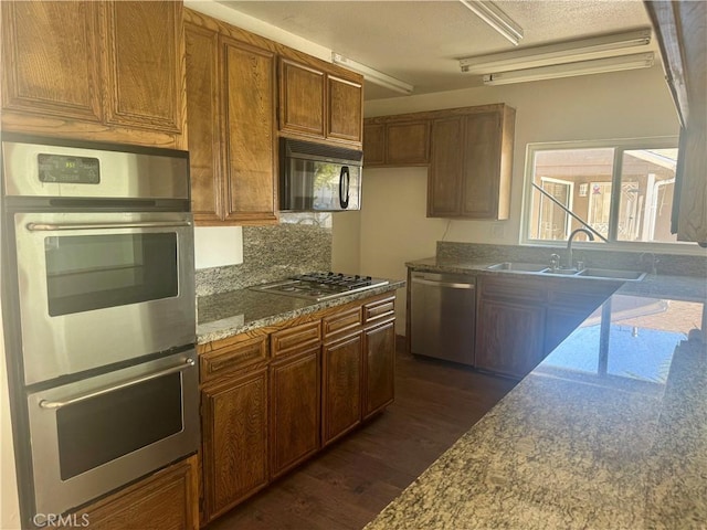 11536 Cimarron Ave, Hawthorne, CA 90250 - kitchen featuring stainless steel appliances, dark wood-style floors, a sink, decorative backsplash, and dark stone countertops