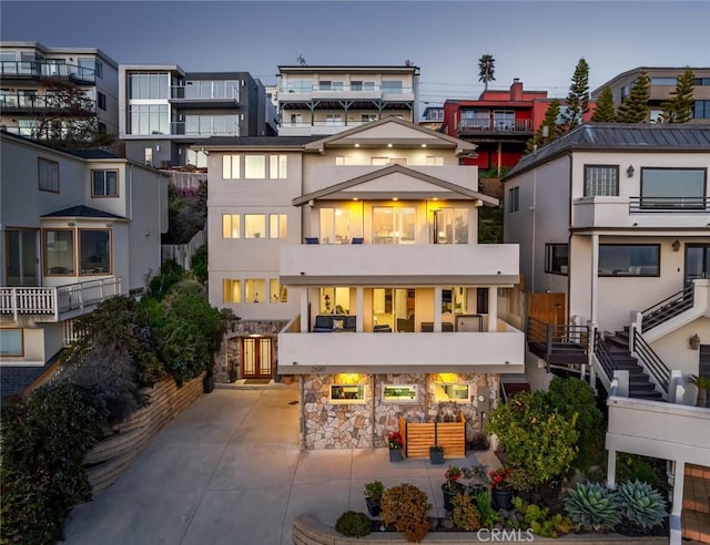 back of property with stucco siding, a balcony, and a patio
