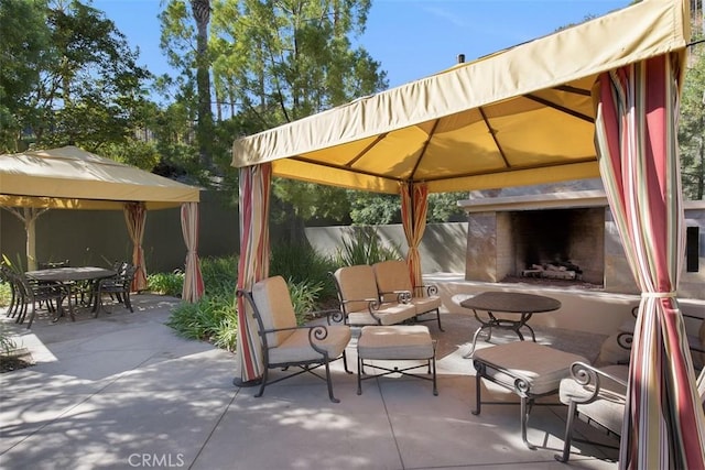 24247 Songsparrow Ln, Corona, CA 92883 - view of patio with a gazebo, exterior fireplace, fence, and outdoor dining space