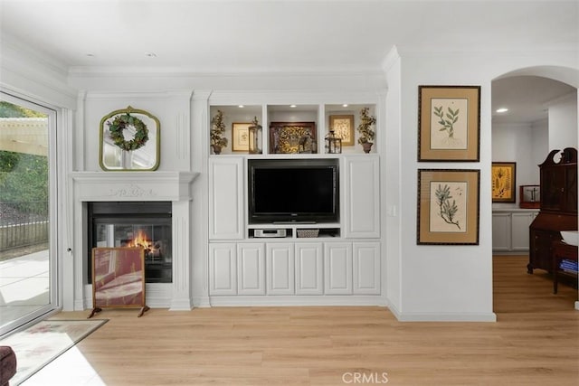 24247 Songsparrow Ln, Corona, CA 92883 - living room featuring light wood-type flooring, arched walkways, ornamental molding, a glass covered fireplace, and baseboards