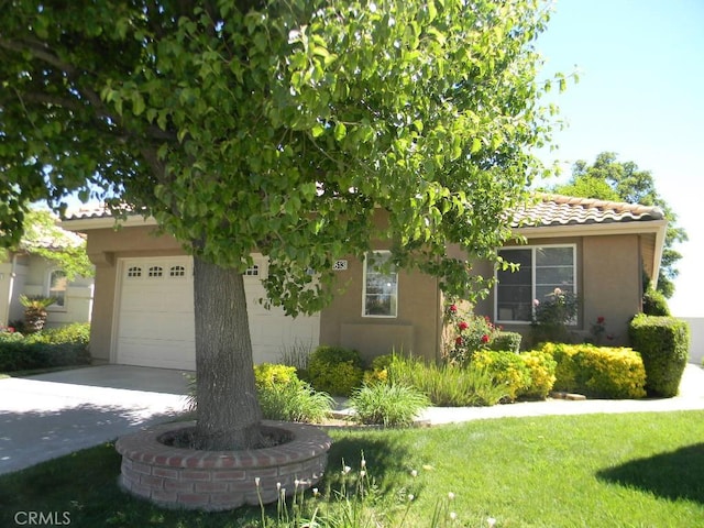 613 Big Spring Dr, Banning, CA 92220 - obstructed view of property with a tiled roof, stucco siding, a garage, driveway, and a front yard