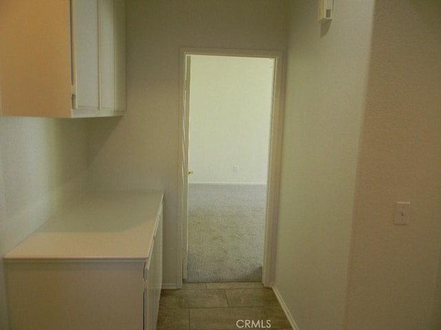 613 Big Spring Dr, Banning, CA 92220 - kitchen featuring white cabinets, light countertops, baseboards, and light carpet