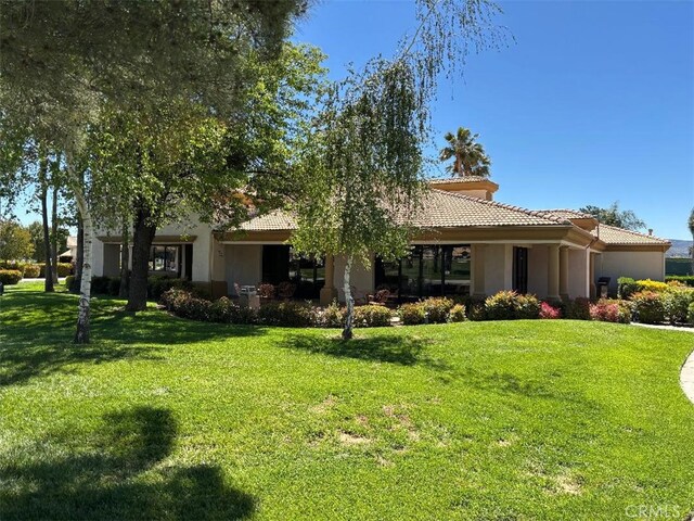 613 Big Spring Dr, Banning, CA 92220 - view of front facade with a tile roof, a front yard, and stucco siding