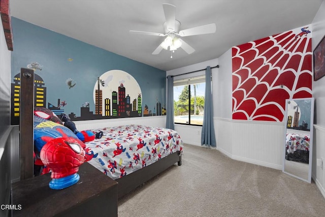 bedroom with wainscoting, carpet, and ceiling fan