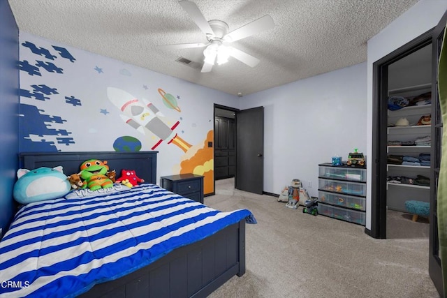 bedroom with carpet, a textured ceiling, and a ceiling fan