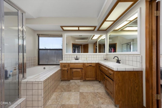 full bath with backsplash, a shower stall, a garden tub, and double vanity
