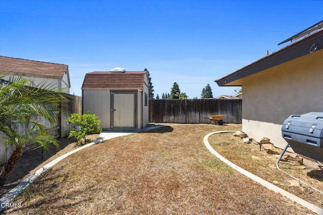 fenced backyard featuring a storage unit and an outdoor structure