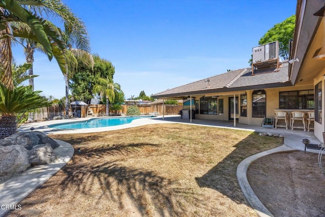 view of pool with cooling unit, a patio area, and a fenced backyard