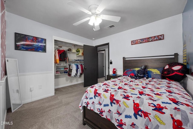 bedroom featuring carpet flooring, wainscoting, ceiling fan, and a closet