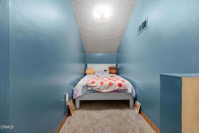 carpeted bedroom with a textured ceiling and baseboards