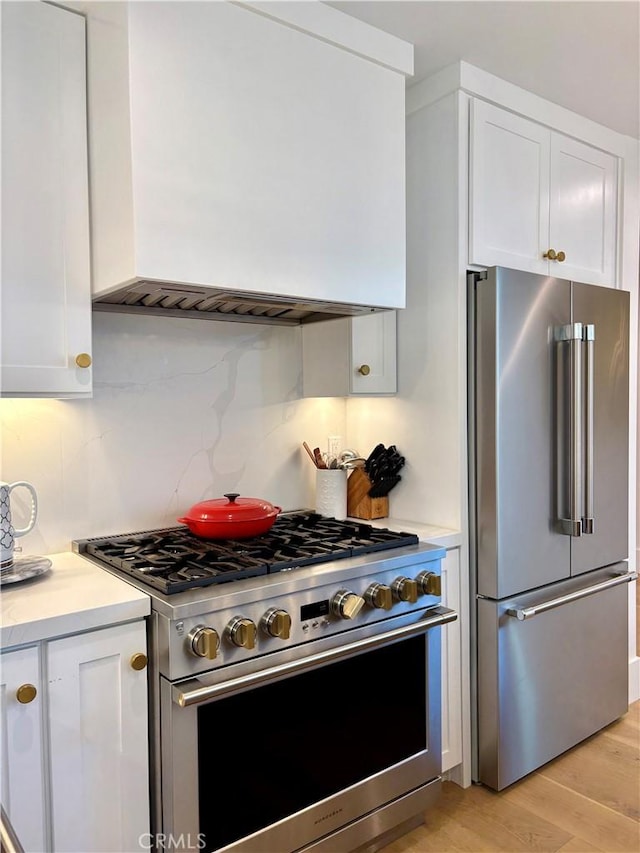 2621 Gates Ave Unit B, Redondo Beach, CA 90278 - kitchen with high end appliances, range hood, light countertops, white cabinets, and light wood-type flooring