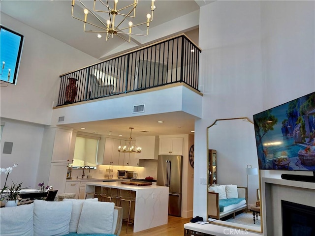 2621 Gates Ave Unit B, Redondo Beach, CA 90278 - living area with a chandelier, a high ceiling, light wood-type flooring, and a fireplace