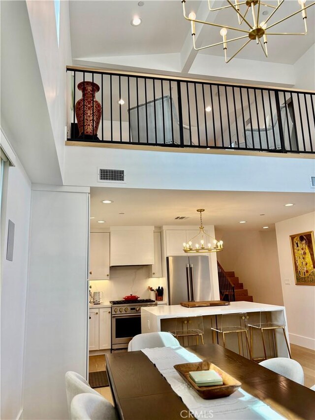 2621 Gates Ave Unit B, Redondo Beach, CA 90278 - dining room with a chandelier, a towering ceiling, stairs, light wood-style floors, and recessed lighting