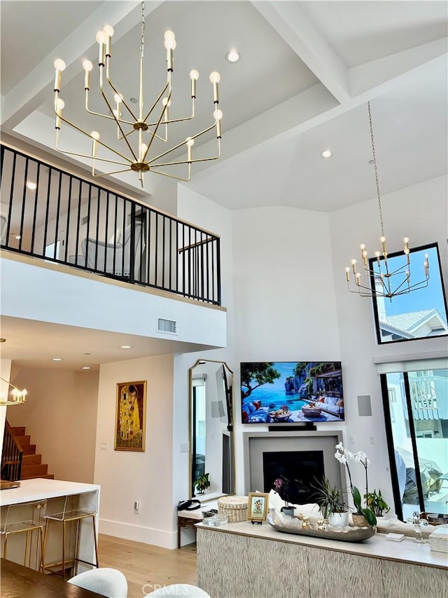 2621 Gates Ave Unit B, Redondo Beach, CA 90278 - living room with a chandelier, a towering ceiling, stairs, light wood-type flooring, and baseboards