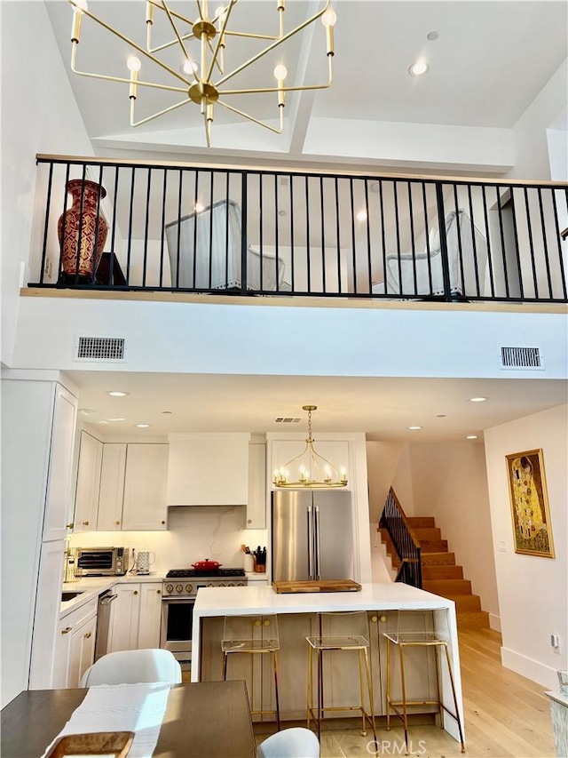 2621 Gates Ave Unit B, Redondo Beach, CA 90278 - kitchen featuring premium appliances, a chandelier, white cabinets, light wood-type flooring, and light countertops
