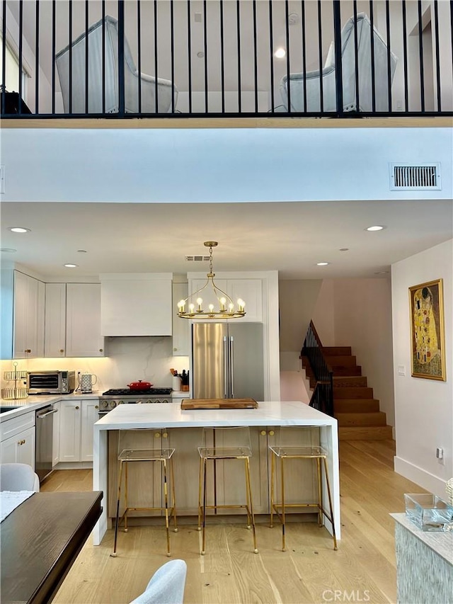 2621 Gates Ave Unit B, Redondo Beach, CA 90278 - kitchen featuring stainless steel appliances, white cabinets, a spacious island, baseboards, and light countertops