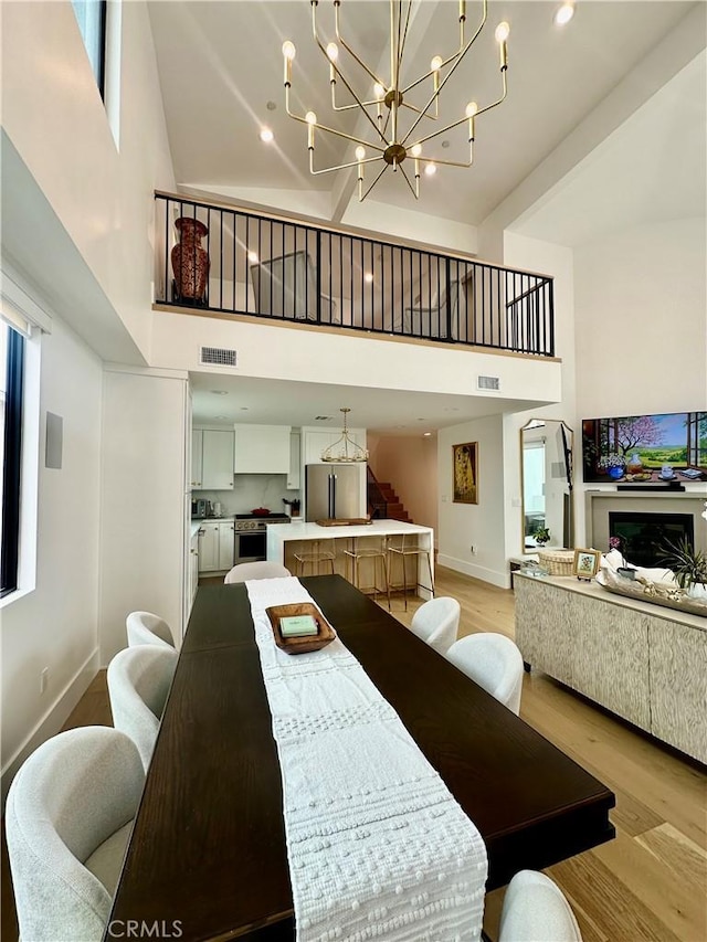 2621 Gates Ave Unit B, Redondo Beach, CA 90278 - dining room featuring a high ceiling, light wood-style flooring, a chandelier, and baseboards
