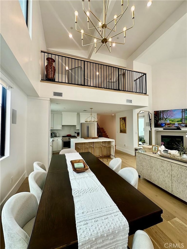 2621 Gates Ave Unit B, Redondo Beach, CA 90278 - dining space featuring a towering ceiling, light wood finished floors, a chandelier, and plenty of natural light