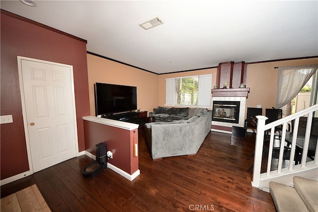 3509 E Berkshire Ct Unit C, Orange, CA 92869 - living room featuring a tiled fireplace, ornamental molding, stairs, wood-type flooring, and baseboards