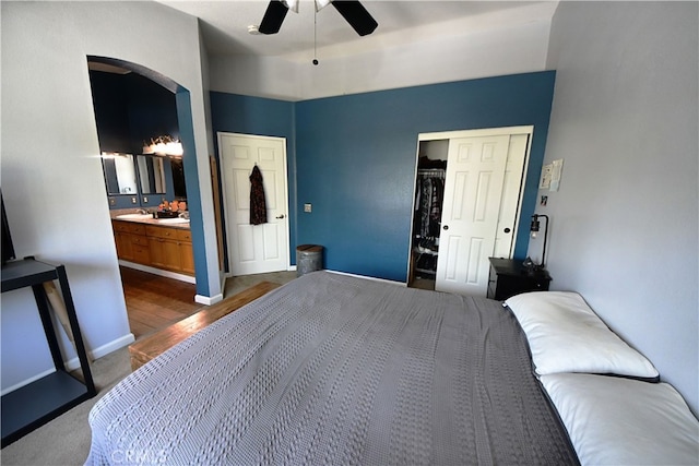 3509 E Berkshire Ct Unit C, Orange, CA 92869 - bedroom featuring arched walkways, a closet, ensuite bathroom, dark wood finished floors, and ceiling fan