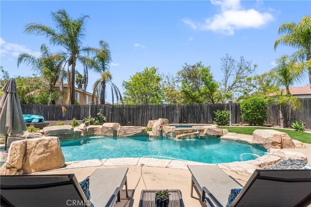 view of swimming pool featuring a fenced backyard, a patio area, and a pool with connected hot tub