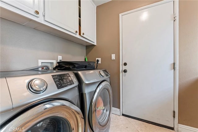 laundry area featuring independent washer and dryer, cabinet space, baseboards, and light tile patterned flooring