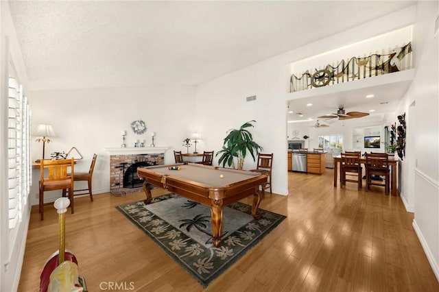 rec room with billiards table, a fireplace, wood finished floors, and baseboards