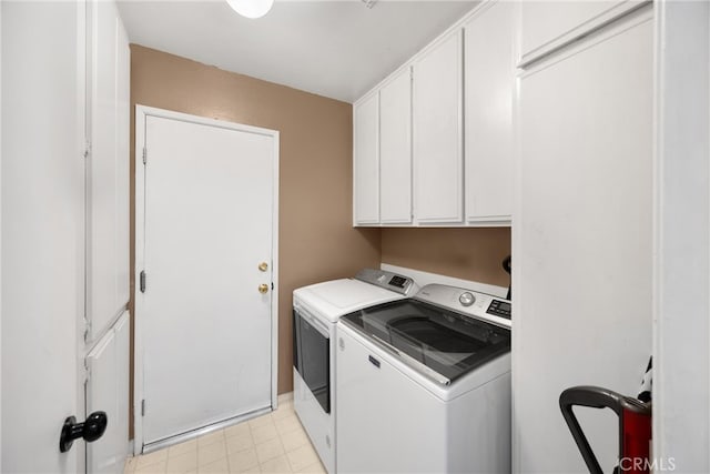 clothes washing area featuring washing machine and clothes dryer, cabinet space, and baseboards