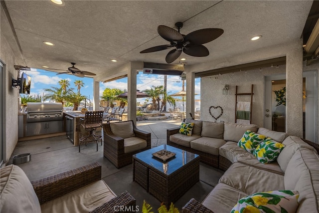 view of patio featuring a ceiling fan, a grill, exterior kitchen, and an outdoor hangout area