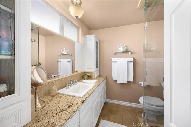 full bath featuring baseboards, tile patterned floors, a stall shower, vanity, and toilet