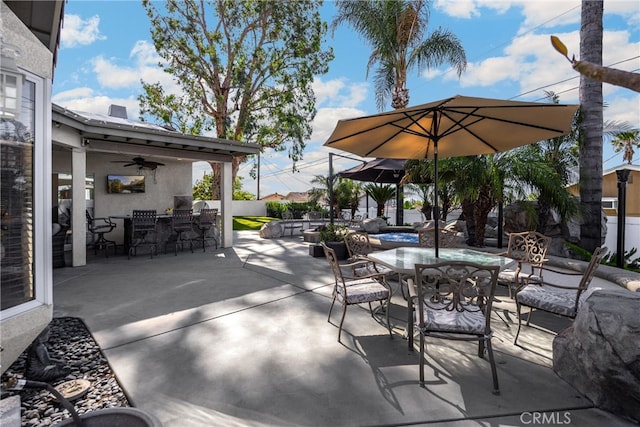 view of patio featuring ceiling fan, outdoor dining area, and a bar