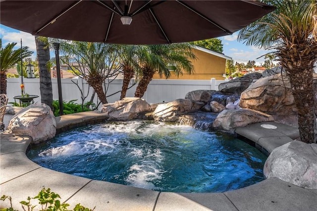 view of pool featuring fence and an outdoor hot tub