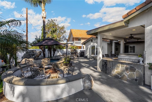 view of patio featuring exterior kitchen, an outdoor living space, ceiling fan, and a grill