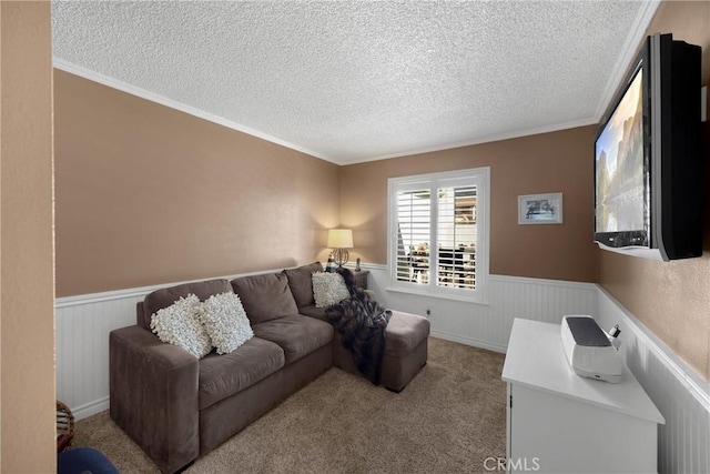 living area featuring a wainscoted wall, a textured ceiling, crown molding, and carpet floors