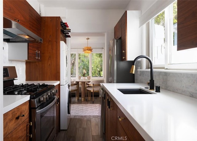 565 Lombardy Ln, Laguna Beach, CA 92651 - kitchen with stainless steel appliances, a sink, light countertops, under cabinet range hood, and dark wood-type flooring