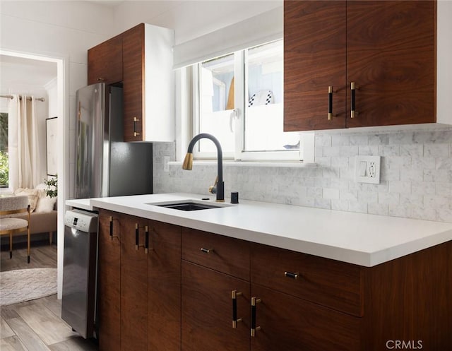 565 Lombardy Ln, Laguna Beach, CA 92651 - kitchen featuring stainless steel dishwasher, light countertops, backsplash, and light wood finished floors