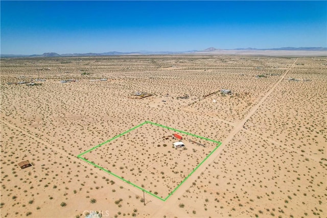 aerial view of sparsely populated area featuring mountains, a desert landscape, and property boundaries highlighted