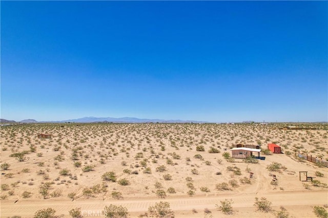 view of yard featuring view of desert landscape, a view of rural / pastoral area, and a mountain view
