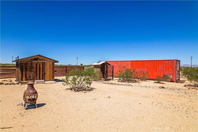 view of yard featuring an outbuilding and fence