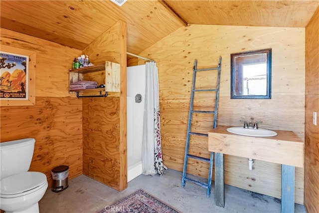 bathroom with lofted ceiling, a shower with curtain, concrete floors, toilet, and wood walls