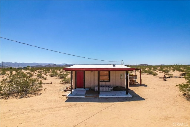 view of outdoor structure featuring a mountain view and a desert view