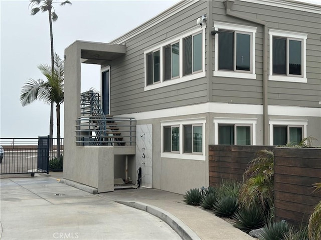 1202 N Pacific St Unit 204A, Oceanside, CA 92054 - rear view of property featuring fence, stucco siding, a patio, and stairway