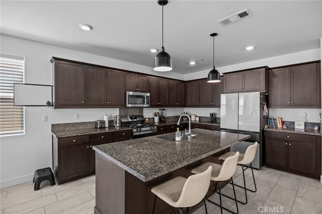 62892 Loftwood St, Desert Hot Springs, CA 92240 - kitchen with appliances with stainless steel finishes, a sink, dark brown cabinetry, a kitchen breakfast bar, and decorative light fixtures