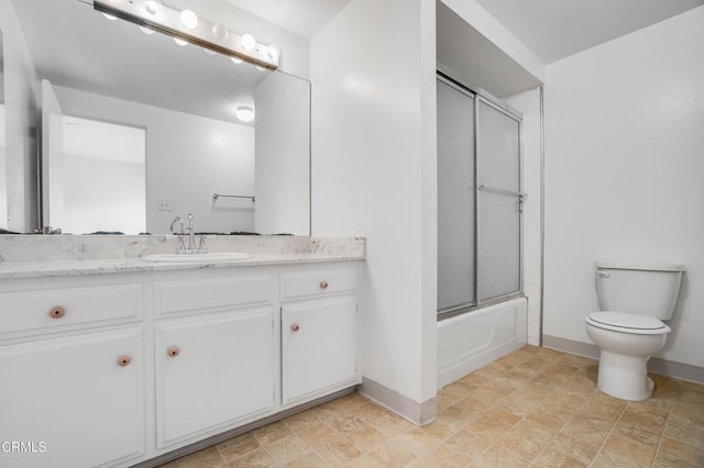 4213 Sarah St Unit 22, Burbank, CA 91505 - bathroom with toilet, baseboards, vanity, combined bath / shower with glass door, and stone finish flooring