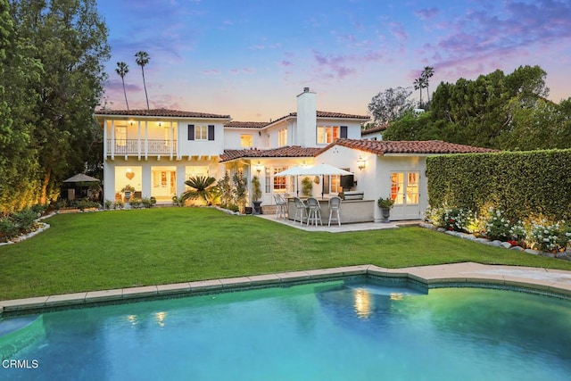 670 San Marino Ave, San Marino, CA 91108 - back of house at dusk featuring a chimney, french doors, a balcony, and a yard