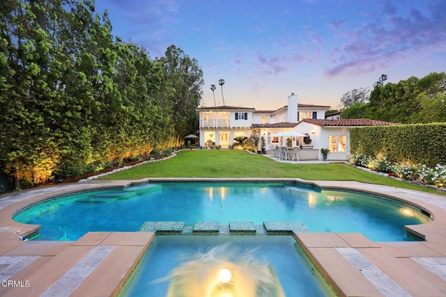 670 San Marino Ave, San Marino, CA 91108 - pool at dusk featuring a pool with connected hot tub, a lawn, and a patio area