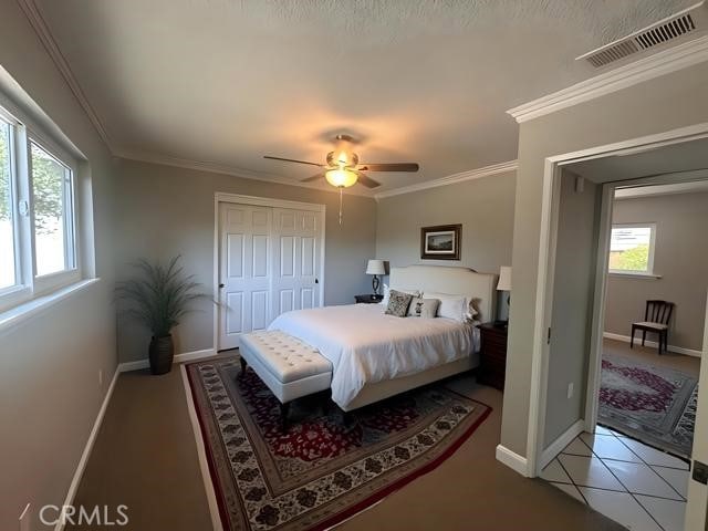 410 Orange Ave, Los Banos, CA 93635 - tiled bedroom featuring ornamental molding, a ceiling fan, and a closet