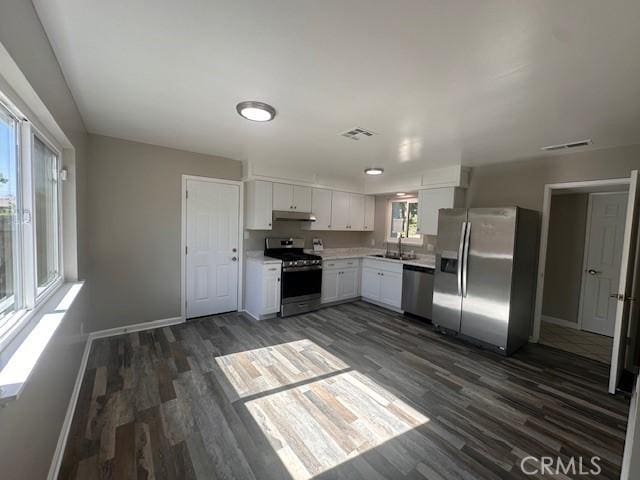 410 Orange Ave, Los Banos, CA 93635 - kitchen featuring stainless steel appliances, dark wood-type flooring, white cabinetry, light countertops, and under cabinet range hood