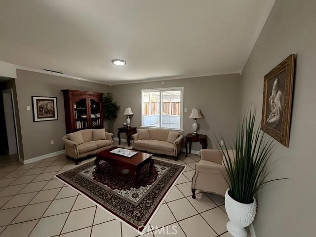 410 Orange Ave, Los Banos, CA 93635 - living area with crown molding, baseboards, and light tile patterned flooring