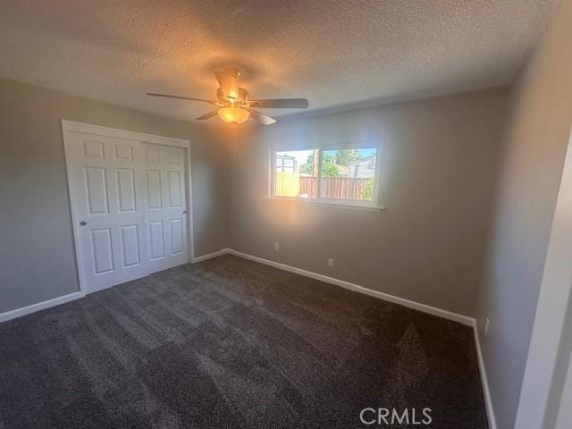 410 Orange Ave, Los Banos, CA 93635 - unfurnished bedroom featuring a textured ceiling, dark carpet, and ceiling fan